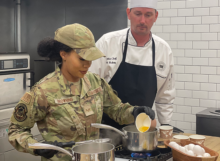 chef training military staff in kitchen